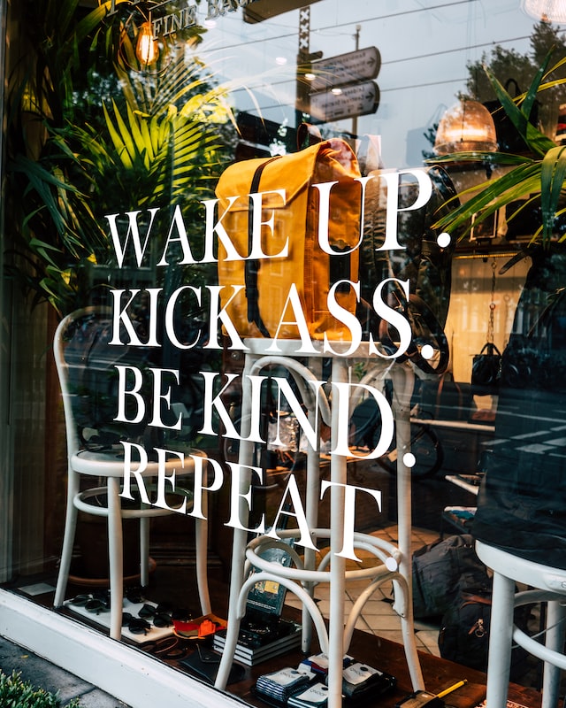 Shop window with the message Wake up, kick ass, be kind, repeat